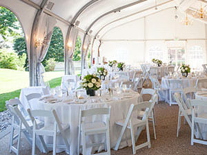 Formal wedding reception under outdoor tent 