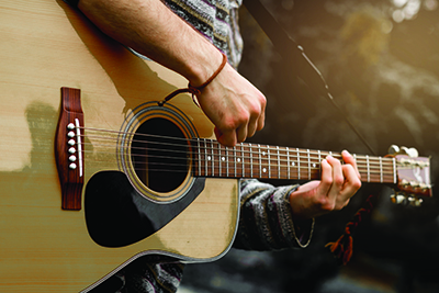 Close up image of person playing the guitar