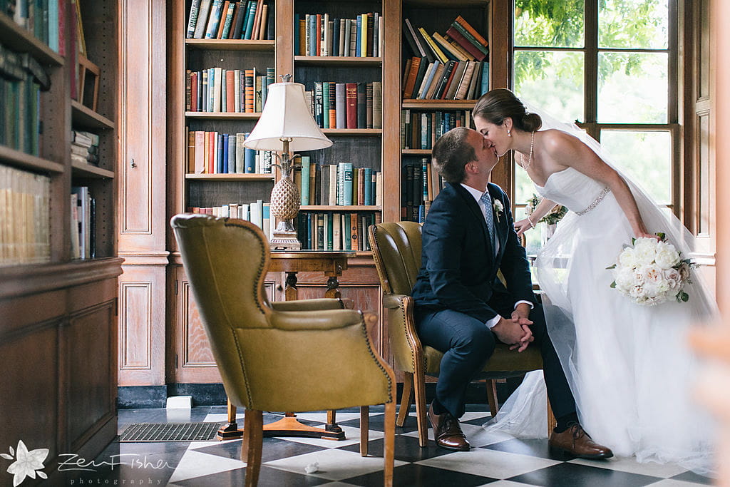 Bride and groom kissing in Misselwood House library
